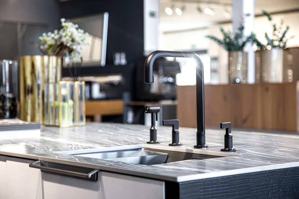 A bright modern kitchen with matte black faucets