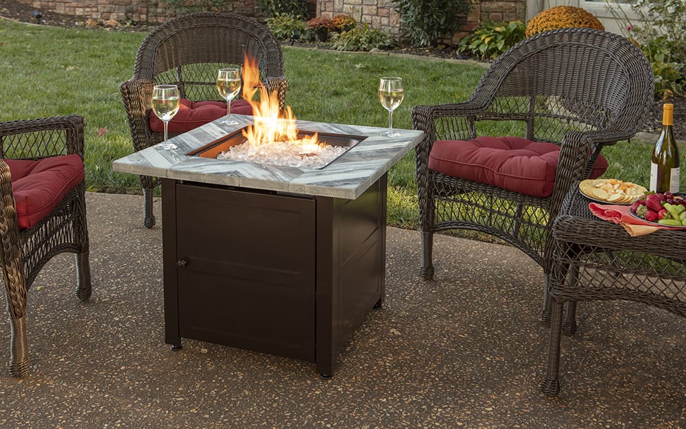 An outdoor dining area with a fire glass propane firepit