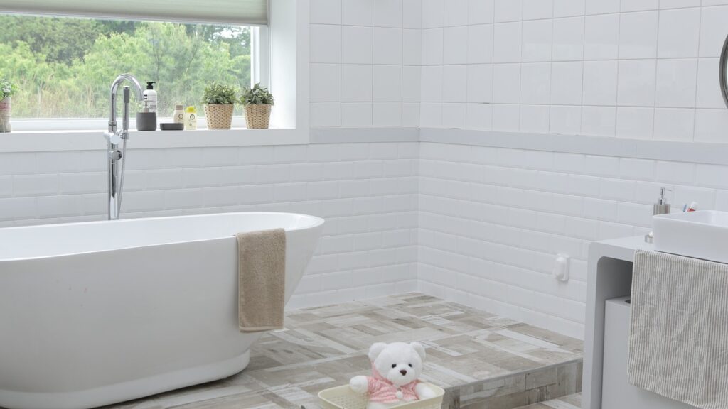 White and natural wood bathroom remodel with a bathtub and a teddy bear