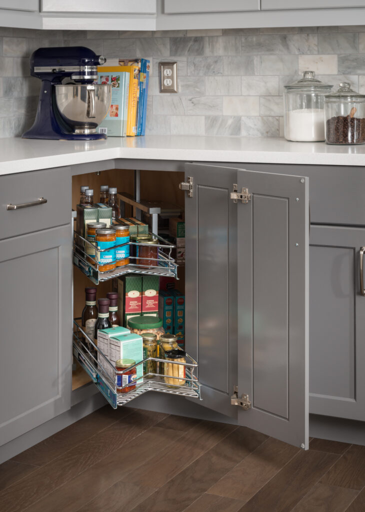 A cabinet door open showing the middle shelf of a 360 Lazy Susan pulled out towards the kitchen