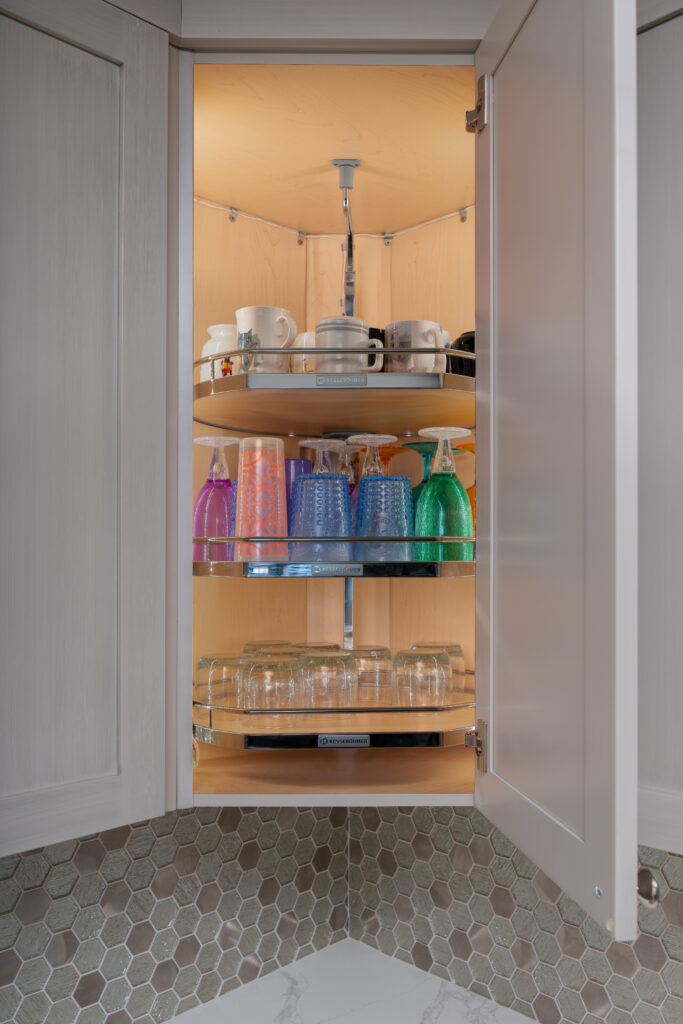 A vertical kitchen storage solution for angled corner cabinets, featuring 3 shelves and an offset post
