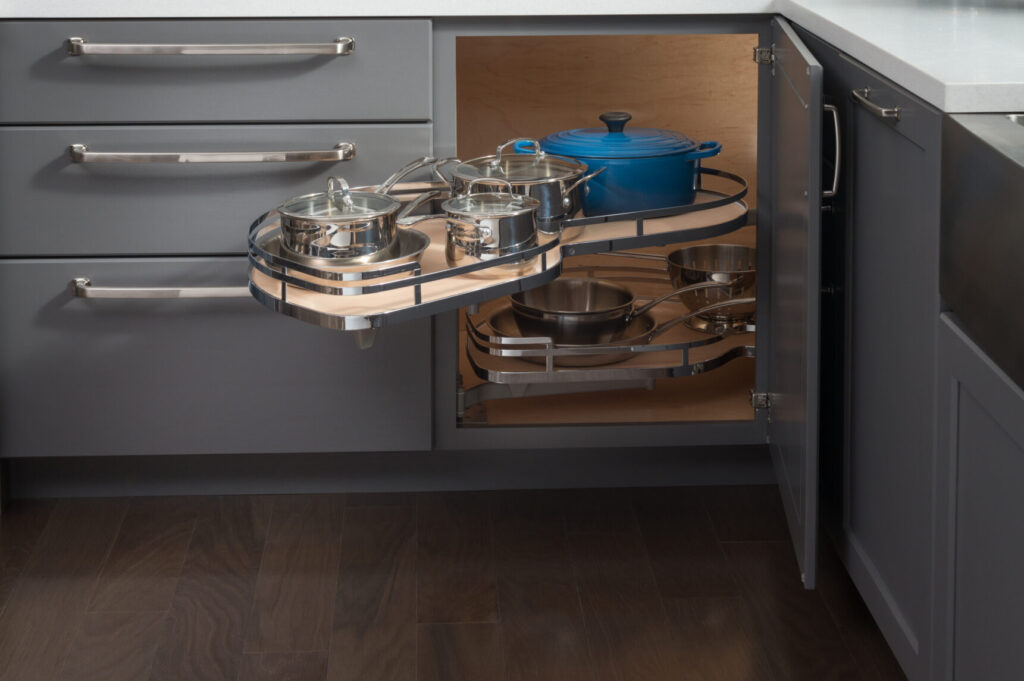 Kitchen storage on two swingout shelves in a corner cabinet, holding pots and pans