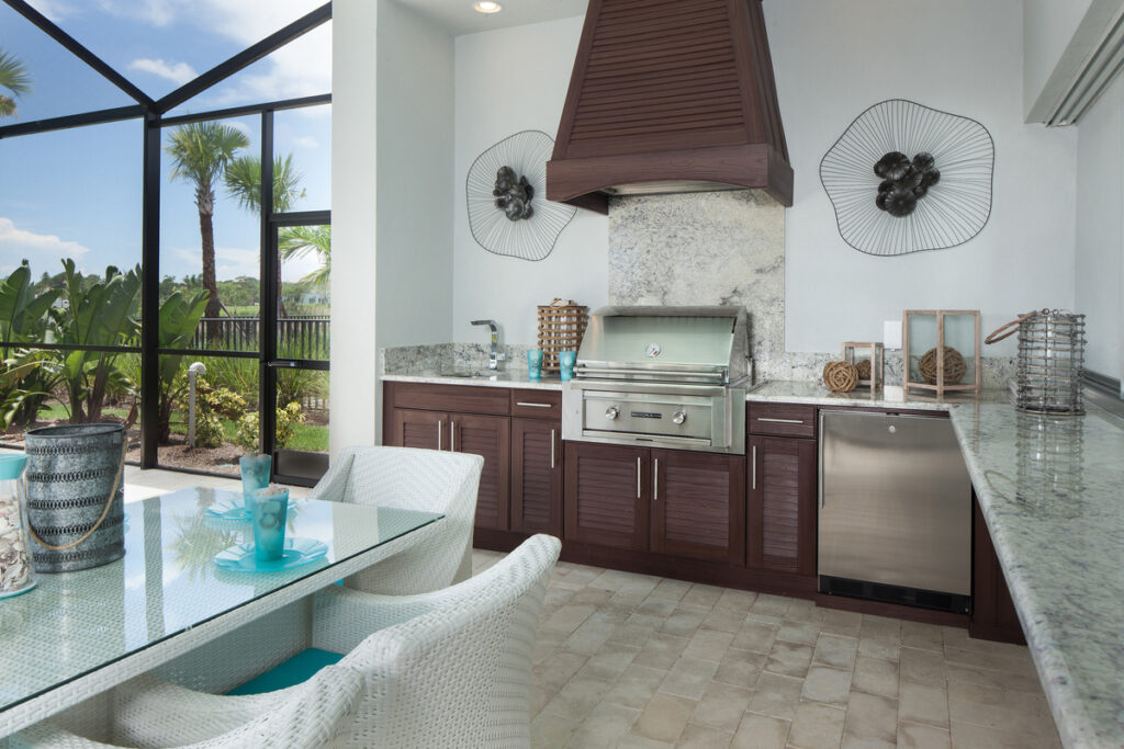 Outdoor kitchen with Naturekast cabinets, stone flooring, and beachhouse decor