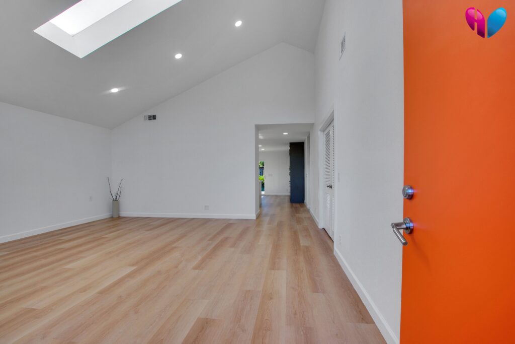 An open entryway with a warm SPC flooring from entryway to kitchen in the background